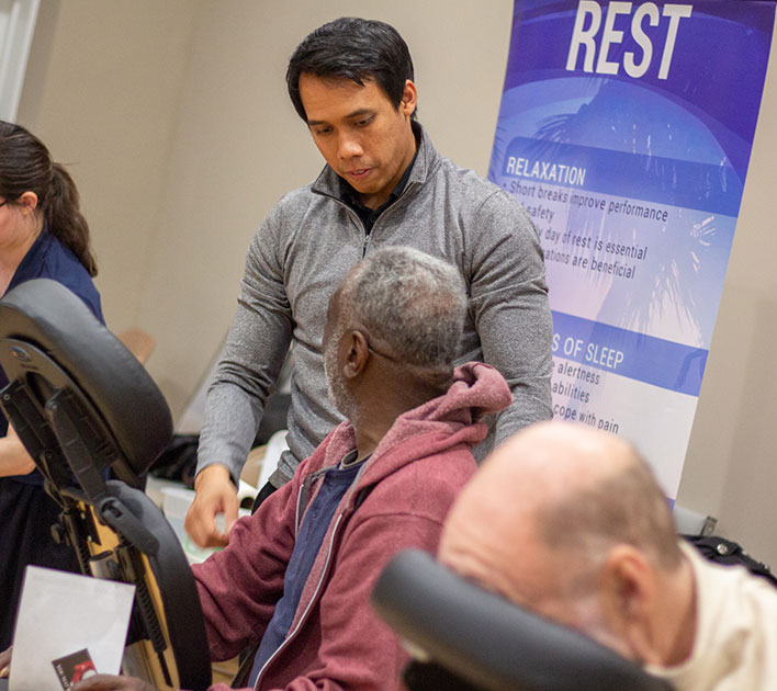 Wildwood health educator giving a chair massage demonstration at a community health seminar